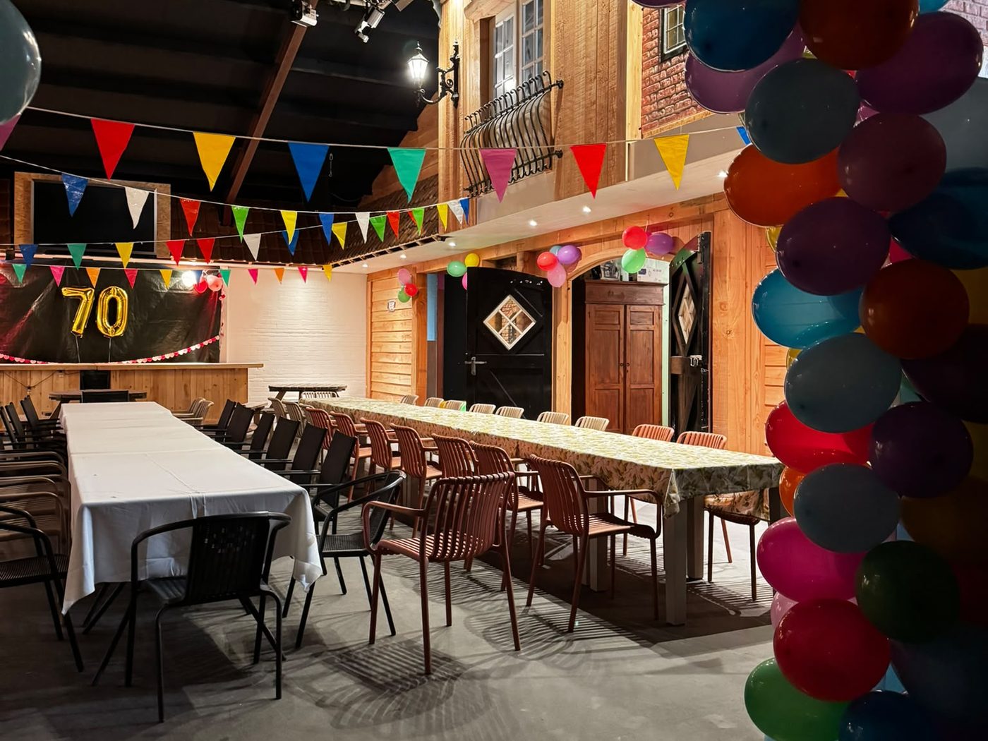Feestzaal van De Hoeverij versierd met ballonnen en lange feesttafels