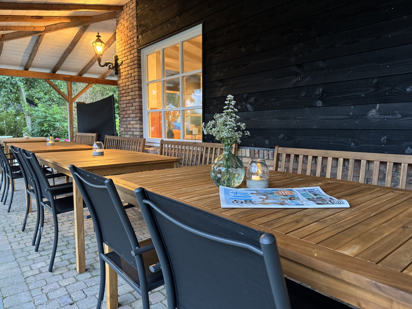 Overdekt terras met lange tafels bij De Hoeverij